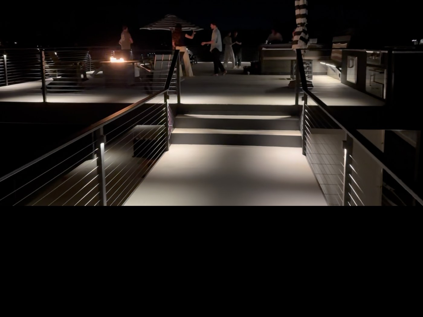 Deck walkway lights, outdoor kitchen LEDs, and fire pit installed by Longhorn Electric